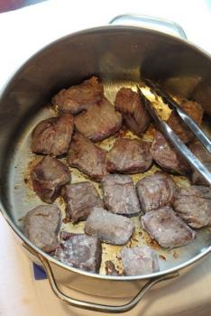 Season the beef and coat in the flour