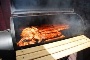 Offset smoker smoking chicken and pork ribs