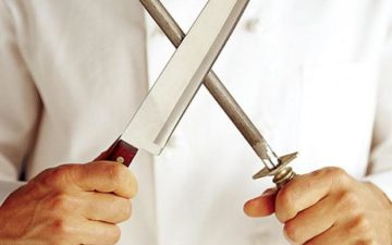 A chef is pictured holding a knife and a honing rod