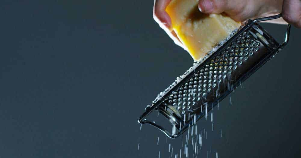 Using a lemon zester to grate cheese