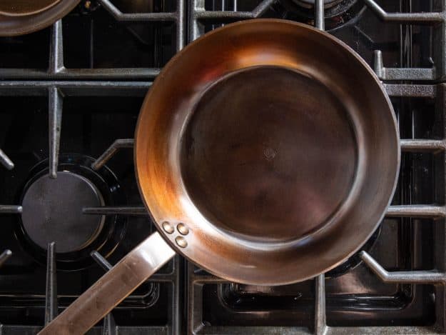 Seasoning carbon steel pan on stovetop