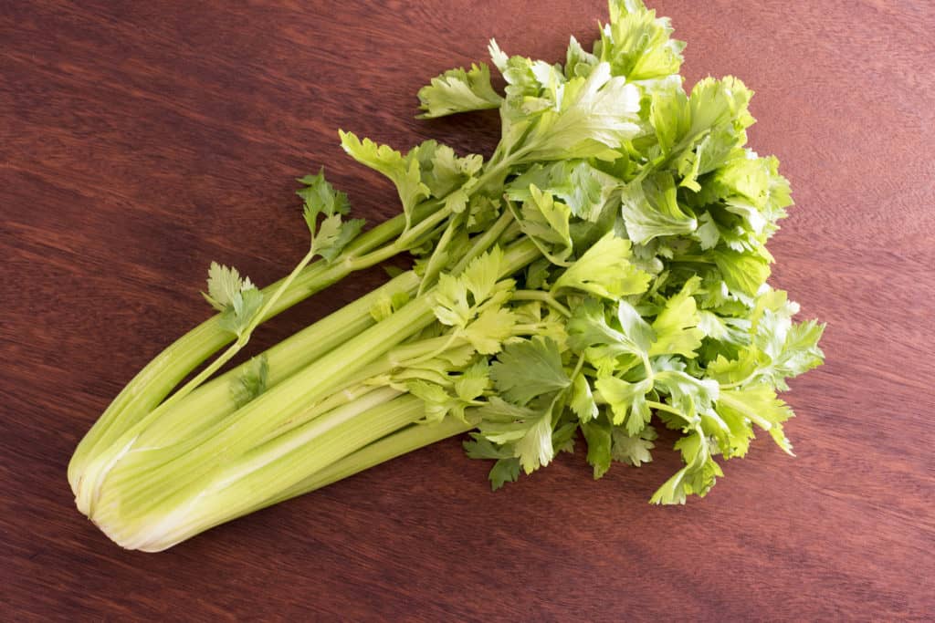 A bunch of celery on brown surface