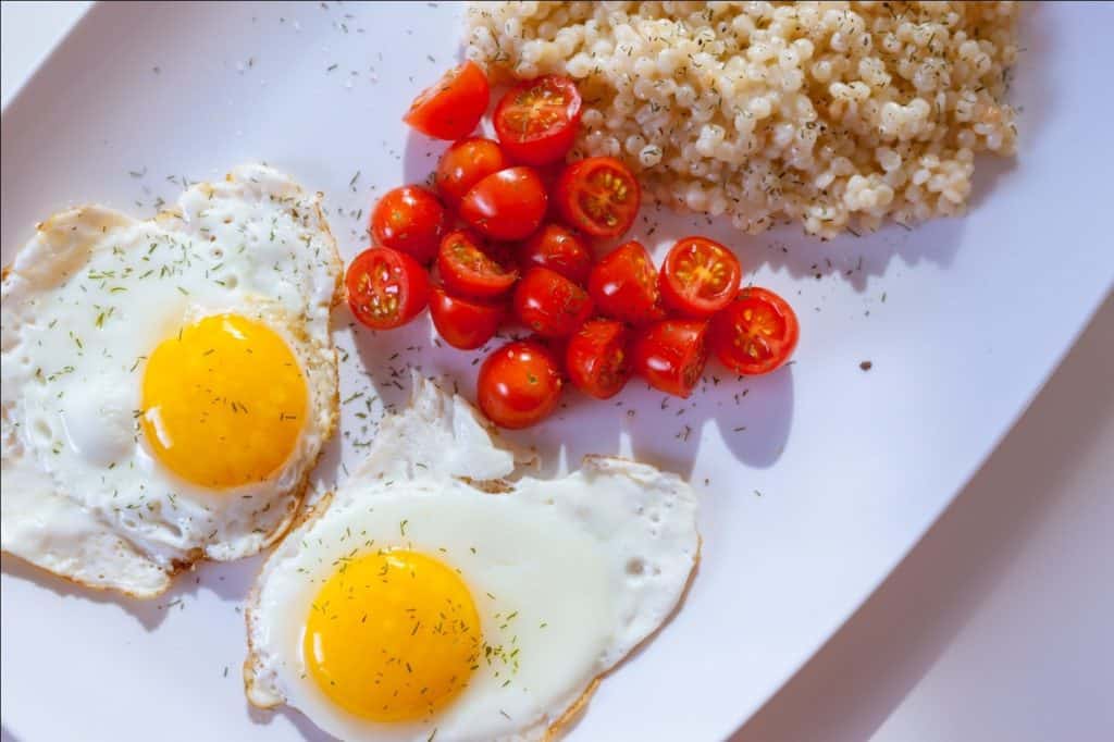 Couscous with cherry tomatoes and fried eggs