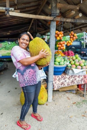 Woman holding a large jackfruit