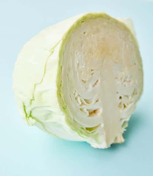 a head of cabbage halved and ready to cut. 