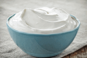 sour cream in a blue bowl on a table. 